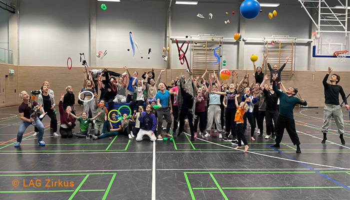 Gruppenbild von Artist*innen in einer Sporthalle